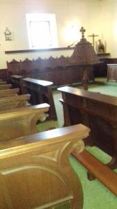 rząd drewnianych ławek w kościele w obiekcie Convento Madre de Dios de Carmona w mieście Carmona