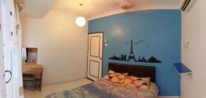 ein Schlafzimmer mit einem Bett und einer blauen Wand in der Unterkunft DT Homestay floor level 4 in Malakka
