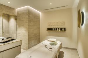 a small bathroom with a bed and a sink at Maison Albar Hotels L’Imperator in Nîmes +122 photos