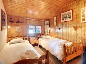 ヴェルビエにあるApartment Summit Comblesの木造キャビン内のベッドルーム1室(ベッド2台付)