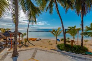 a view of the beach from a resort with palm trees at Puerto Aventuras Hotel & Beach Club in Puerto Aventuras