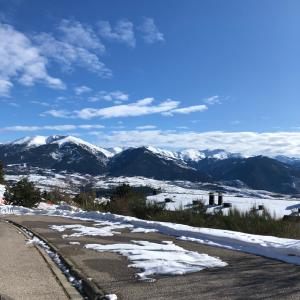 una carretera cubierta de nieve con montañas en el fondo en Charmante Maison de village: Prestation de Qualité, Tout confort, Terrasse, en Targassonne