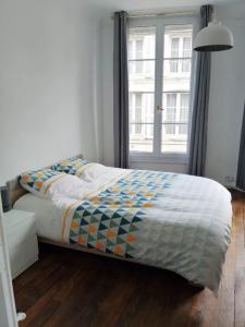 a bed in a room with a large window at Bel appartement ancien Poitiers Centre - 4 Chambres in Poitiers