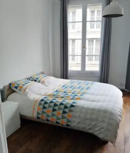 - un lit dans une chambre avec fenêtre dans l'établissement Bel appartement ancien Poitiers Centre - 4 Chambres, à Poitiers