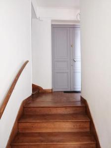 a stairway with a white door and wooden stairs at Bel appartement ancien Poitiers Centre - 4 Chambres in Poitiers