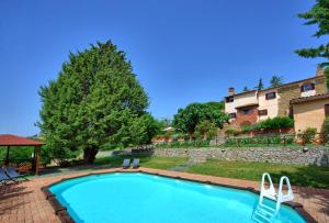 una piscina con 2 sillas y un edificio en Villa Uccellaia by PosarelliVillas, en Agello