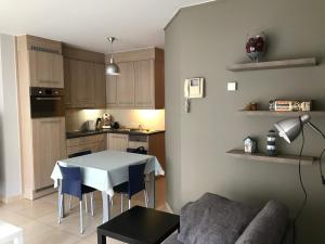 een woonkamer met een tafel en een keuken bij Appartement Koksijde in Koksijde