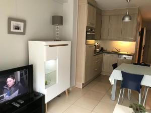 a kitchen with a table and a tv in a room at Appartement Koksijde in Koksijde
