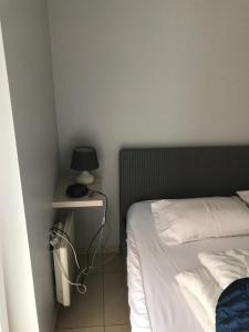1 dormitorio con 1 cama y 1 mesa con lámpara en Appartement Koksijde, en Koksijde