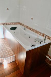 a bath tub in a bathroom with a wooden floor at La Champenoise in Marson