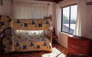 a bedroom with a bed and a window at Ruca de Cura in Cobquecura