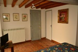 Saints的住宿－Le Vieux Saule，一间卧室配有一张床、一扇门和电视