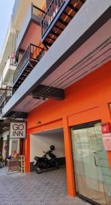 an orange building with a motorcycle parked outside of it at GO INN Chiang Mai University - CMU in Chiang Mai