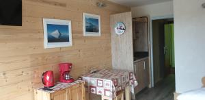 a room with a wooden wall with a counter and a kitchen at Résidence le Galaxie in Villard-de-Lans