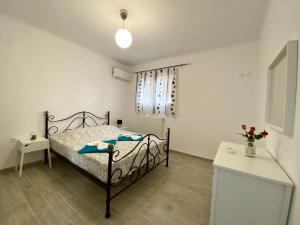 PentátionにあるCoralli Pentati 2 "Dimitris Apartments"の小さなベッドルーム(ベッド1台、テーブル付)