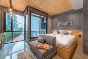 a bedroom with a king sized bed and a chair at Лофт-студия 10 минут до пляжа B228 by IBG Property in Nai Harn Beach