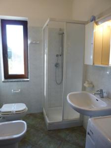 een badkamer met een douche, een toilet en een wastafel bij LE MAREE I LENTISCHI in San Teodoro