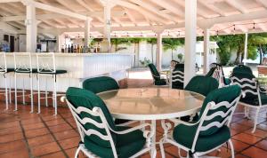 a restaurant with a table and green chairs at Royal Glitter Bay Villas in Saint James