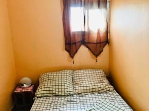 - une petite chambre avec un lit et une fenêtre dans l'établissement Vicky Appartements Palmengarten Douala Maképè Belavie, à Douala