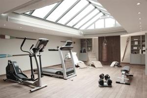 a gym with several exercise equipment in a room with a skylight at von Deska Townhouses - White House in Hamburg