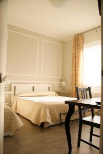 a bedroom with a bed and a table and a window at LA DAMA ROOM&BREAKFAST in Russi