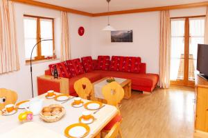 sala de estar con sofá rojo y mesa en Haus Alois en Mittenwald