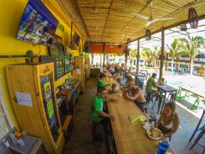 a group of people sitting at a table in a restaurant at Wild Rover Beach Mancora in Máncora