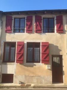 un edificio con persianas rojas y una puerta en La Tanière en Sorcy-Saint-Martin
