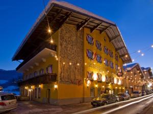żółty budynek z samochodami zaparkowanymi przed nim w obiekcie Hotel Stegerbräu w mieście Radstadt