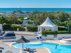 a swimming pool with a white tent and a white tent at Oh! Campings - Le Clos du Rhône in Saintes-Maries-de-la-Mer