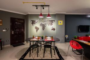 a dining room with a table and a world map on the wall at The Terminal 1 Stay - Steps From Nightlife and Airport in Cairo