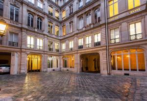 an empty courtyard of a large building with many windows at CMG Concorde/ Madeleine in Paris