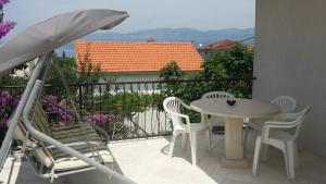 un patio con tavolo, sedie e ombrellone di Apartment Pehi a Supetar (San Pietro di Brazza)