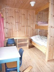 a room with two bunk beds and a table and chairs at Jønndalen Høyfjellseter in Uvdal