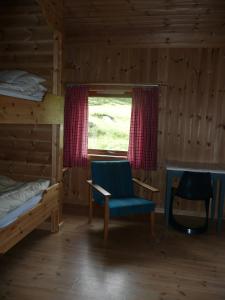 a room with a bed and a chair and a window at Jønndalen Høyfjellseter in Uvdal