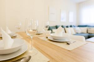 Una mesa con copas de vino y platos encima. en TU DESCANSO, en San José