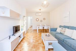 Una sala de estar con un sofá azul y una mesa. en TU DESCANSO, en San José
