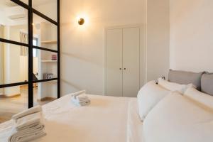 1 dormitorio con cama blanca y espejo en Milan Design Flats, en Milán