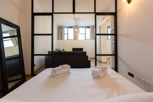 1 dormitorio con 1 cama blanca grande y 2 toallas en Milan Design Flats, en Milán
