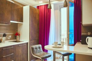 a kitchen with red curtains and a table with chairs at Sauna Jacuzzi Luxury Spa Apartment in Kyiv
