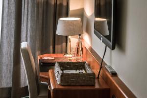 Zimmer mit einem Schreibtisch mit einer Lampe und einem TV in der Unterkunft Gasthaus Spieker in Hövelhof