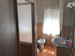a bathroom with a sink and a toilet and a window at Apartamento Ruidera Plaza in Ruidera +8 photos