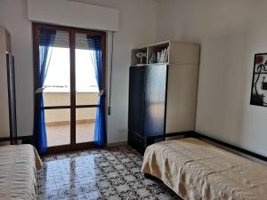 ein Schlafzimmer mit einem Kühlschrank und eine Tür mit einem Fenster in der Unterkunft Appartamento Alba Rosa in Francavilla al Mare