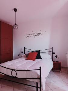 a bedroom with a white bed with a red pillow at La Terrazza Ciampino in Ciampino