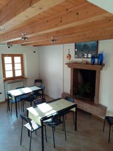 Habitación con mesas, sillas y chimenea. en Ca' del Laki, en Caprino Veronese