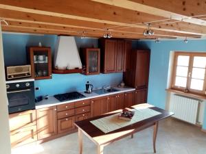 a kitchen with wooden cabinets and a table in it at Ca' del Laki in Caprino Veronese