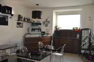 a dining room with two tables and a kitchen at Regalpetra Hotel in Racalmuto