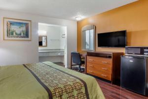 a hotel room with a bed and a desk and a television at Riverside Inn & Suites in Riverside