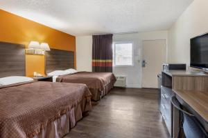 a hotel room with two beds and a flat screen tv at Riverside Inn & Suites in Riverside
