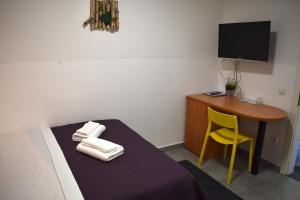 a room with a bed and a desk with a yellow chair at Hotel Fala Zagreb in Zagreb